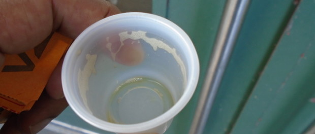 Beer in cough syrup cup. Atwater Market. Oktoberfest. Photo Adam Shaw.