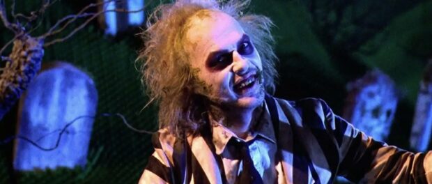 Michael Keaton in white face paint and striped suit as a ghost