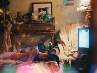 Girl lying on bed in cluttered French style room