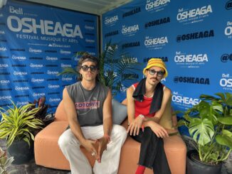 Two men wearing sunglasses sitting on a sofa. Osheaga.